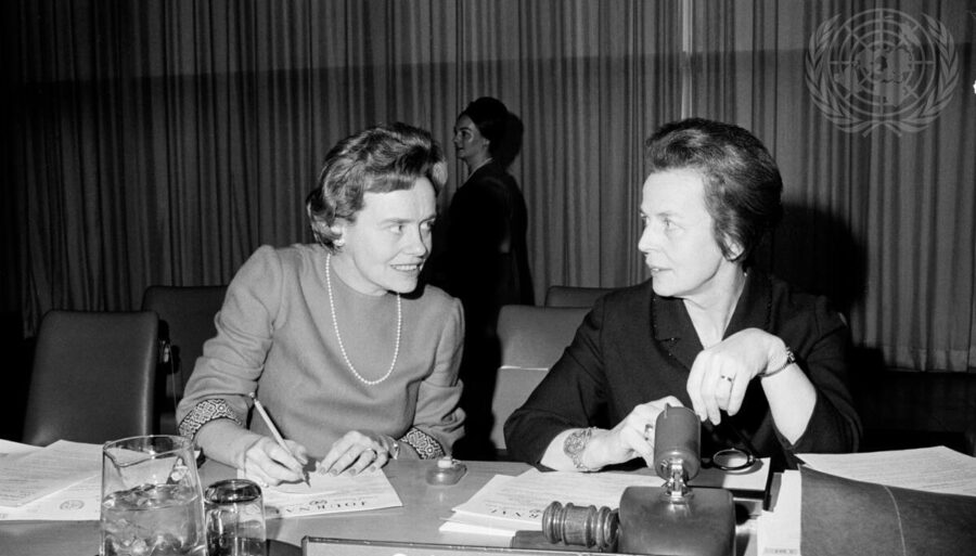 Two women seated at a table behind a 
