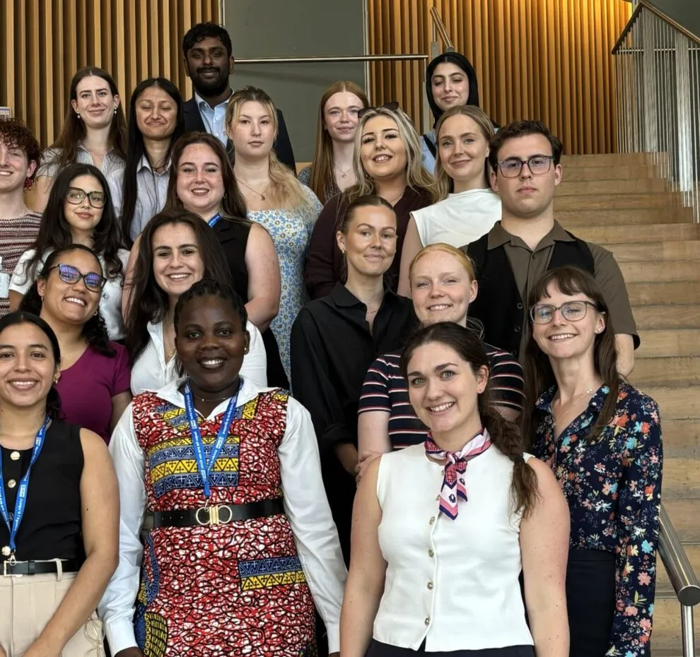 A group of youth delegates posing for a photo on the stairs.